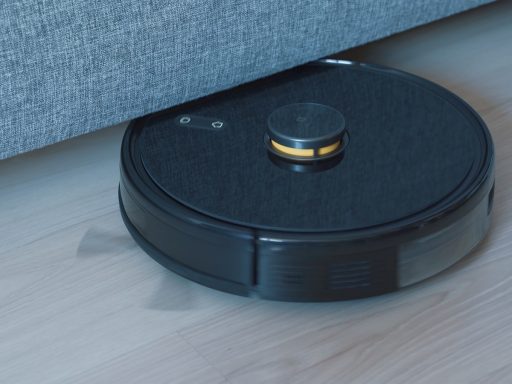 a black robot vacuum on a wooden floor